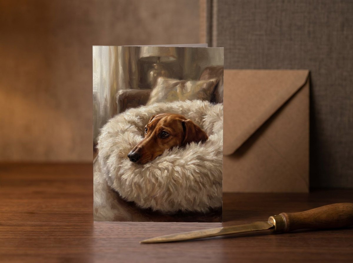 A card standing upright — on a walnut desk with one envelope leaning behind it