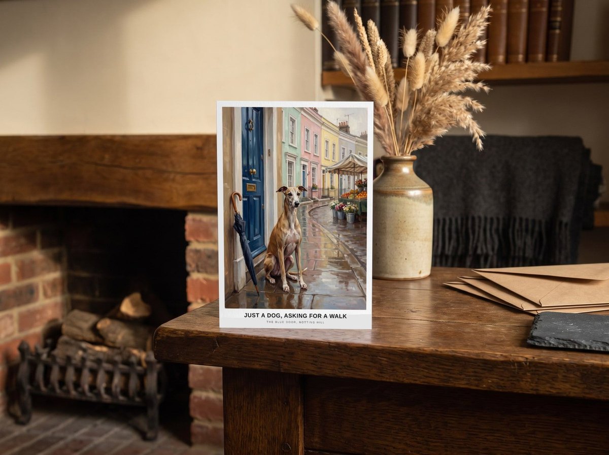 A card standing upright — on an oak mantel beside a vase of dried grasses