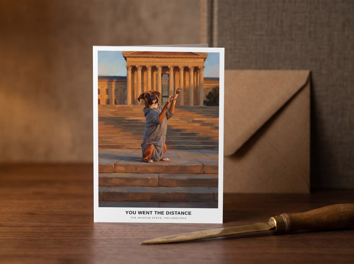 A card standing upright — on a walnut desk with one envelope leaning behind it