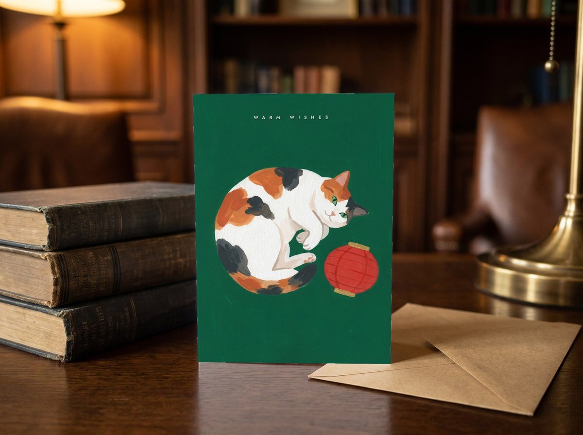 A card standing upright — on a library desk between old books and an envelope