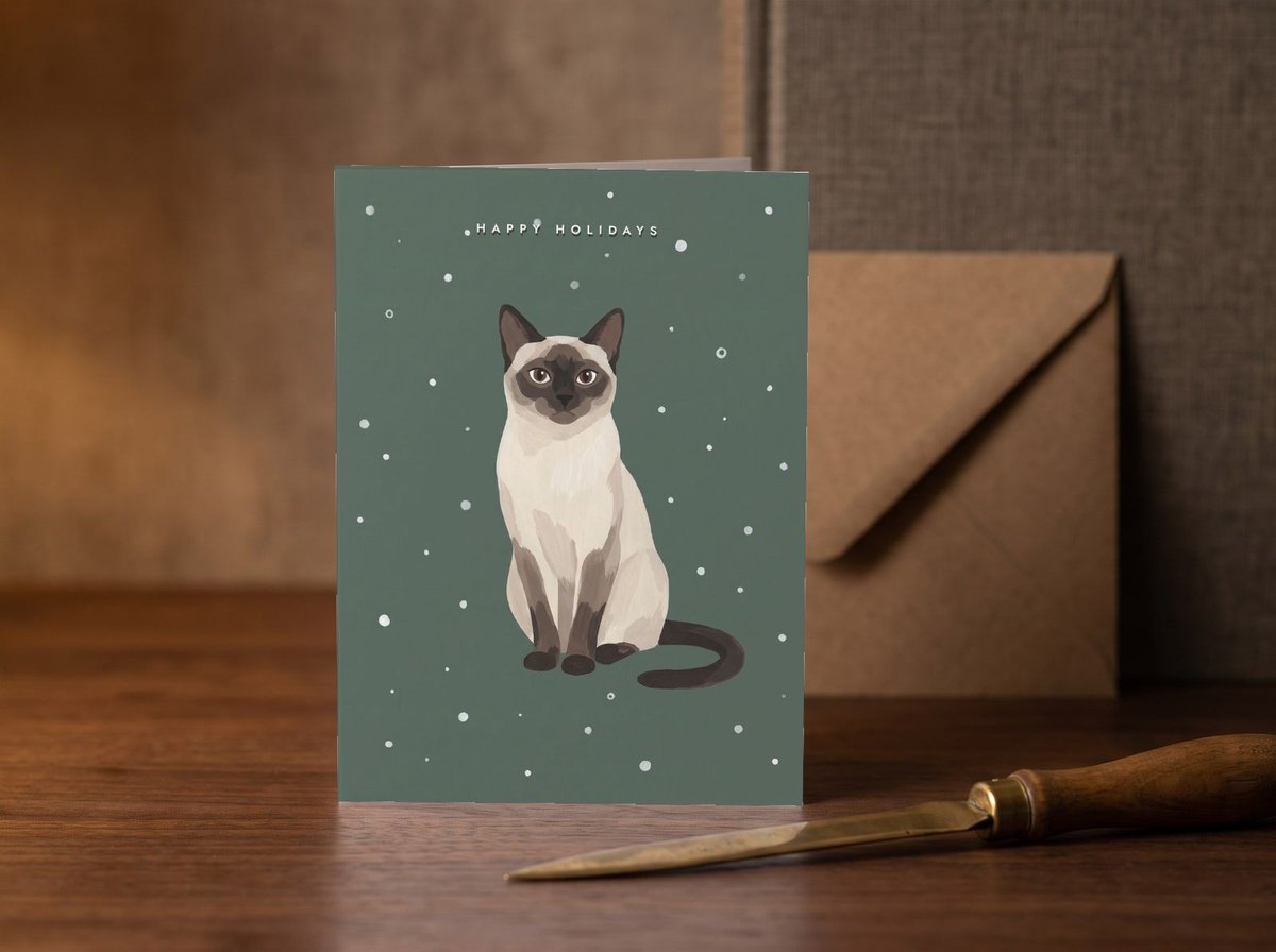 A card standing upright — on a walnut desk with one envelope leaning behind it