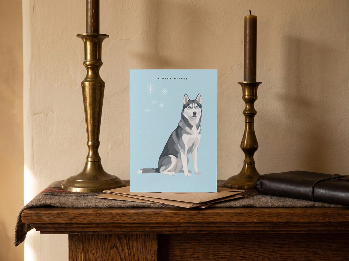 A card standing upright — on a mantel between brass candlesticks